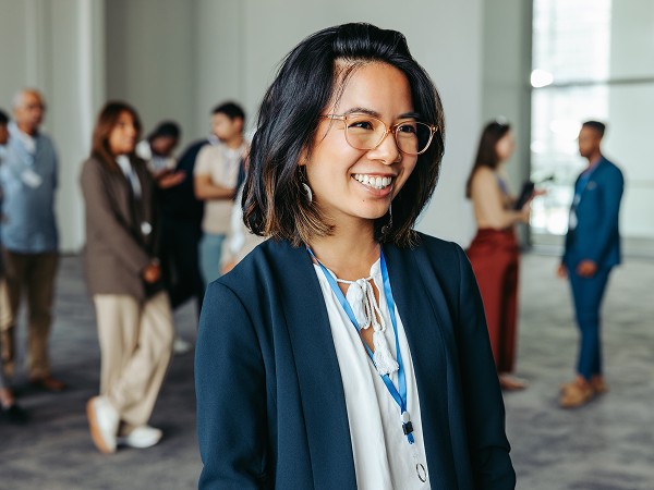 A young man in an office attire with a blue gradient background.