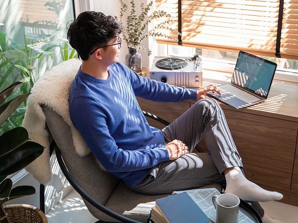 A lady with a laptop sitting in an office building.