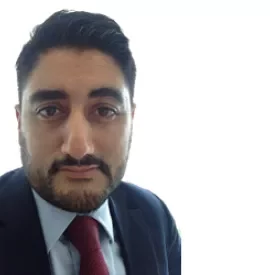 Man in a suit and tie with a neutral expression.