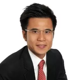 Smiling man in a suit and red tie against a white background.