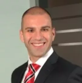 Smiling person in a suit with a red striped tie