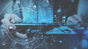 Hands typing on laptop with digital data overlay and holographic elements.