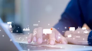 Person typing on a laptop with digital icons representing communication and technology.