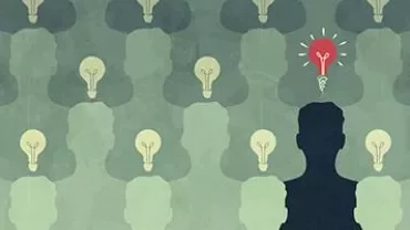 Silhouette with a red light bulb among many gray light bulbs, symbolizing unique ideas.