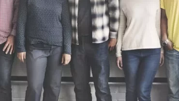 Four people standing side by side, showing casual clothing.
