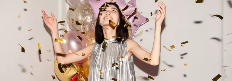 asian woman celebrating hands in the air confetti
