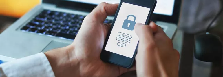 Person holding smartphone with padlock login screen.