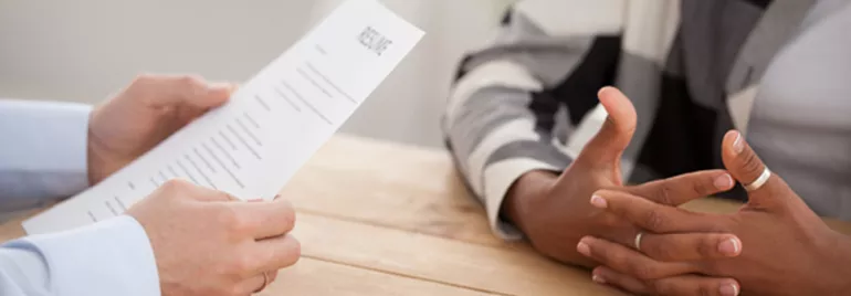 Close-up of a person holding a resume during a job interview.