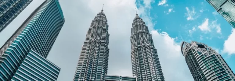 Skyscrapers against a blue sky with clouds.