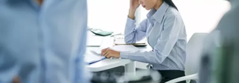 Focused woman in an office working at a desk.