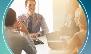 Business meeting with four people around a table.
