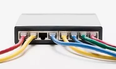 Network cables plugged into a switch, showcasing multiple colored connections.