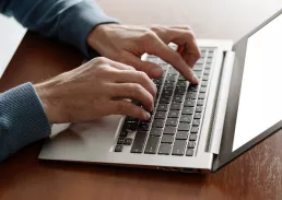 man typing at the laptop