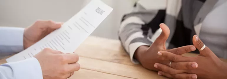 Close-up of a person holding a resume during a job interview.