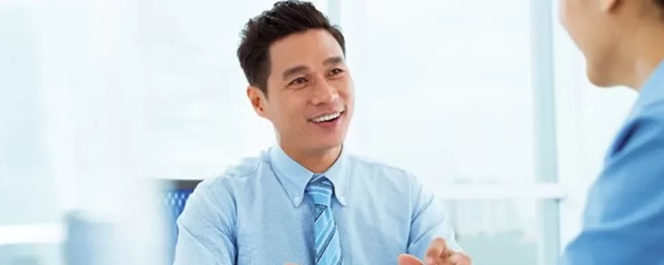 Man in a blue shirt smiling during a conversation.