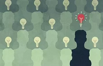 Silhouette with a red light bulb among many gray light bulbs, symbolizing unique ideas.